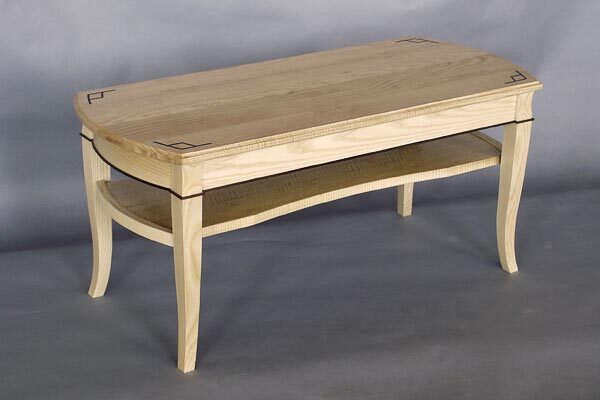 Curly ash coffee table: Ebony inlay, bent laminated white ash, black walnut detail. 42″ l x 17 1/2″ w x 18 1/2″ h