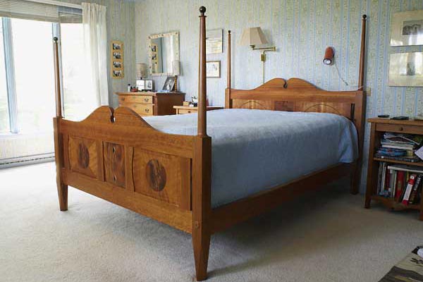 Queen sized bed: cherry Head and Footboards, with crotch-mahogany medallions and rosewood finials