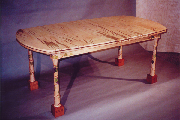 Dining table: This lovely table seats six to ten people. Made of worm hole maple, curly maple, pearwood feet with hand-painted grape vines.